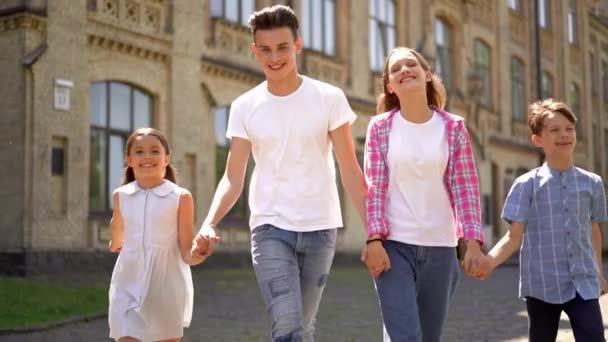 Vista Frontal Familia Feliz Cuatro Caminando Tomados Mano Parque Ciudad — Vídeos de Stock