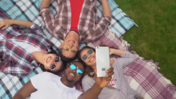 Amigos felices acostados en una alfombra y streaming para redes sociales o amigos . — Vídeos de Stock