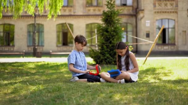Bambini Sono Seduti Sul Prato Vicino Alla Scuola Durante Pausa — Video Stock
