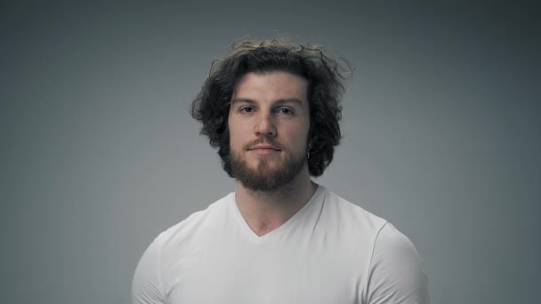 Joven Guapo Con Una Camiseta Blanca Está Pie Sobre Fondo — Vídeos de Stock