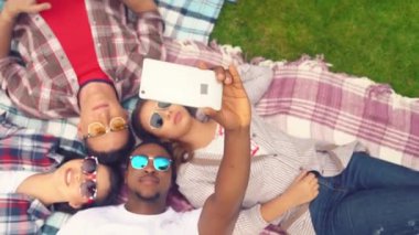 Genel bakış açısına göre grup, ekoseli açık havada selfie çekiyor.