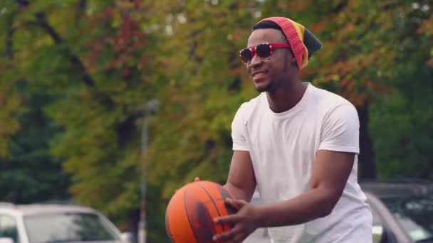 Afrikansk amerikan som leker med basket utomhus. — Stockvideo