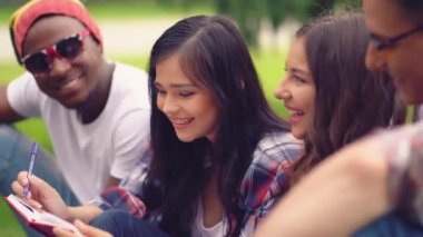 Çömez öğrenciler dışarıda oturup notlar alıyorlar..