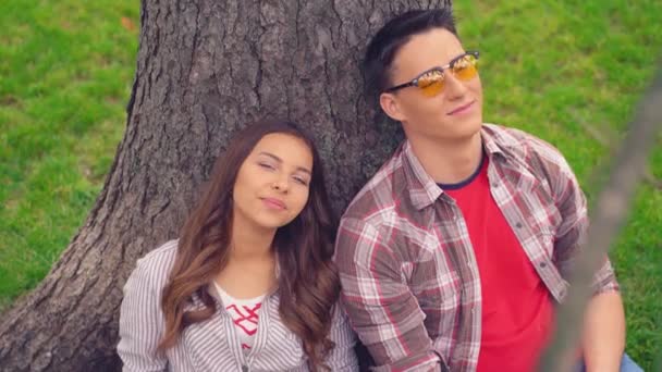 Relajada pareja de jóvenes estudiantes universitarios enamorados por el árbol . — Vídeos de Stock
