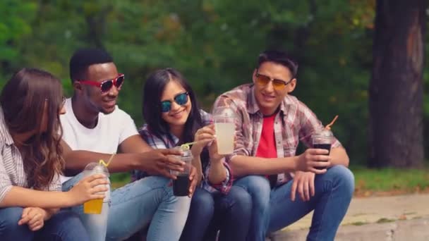 Sorrindo amigos em camus se divertindo bebendo sucos frescos — Vídeo de Stock