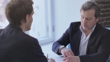 Lokantada oturan iki işadamı.