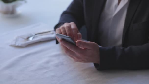 Бізнесмен використовує смартфон у ресторані — стокове відео