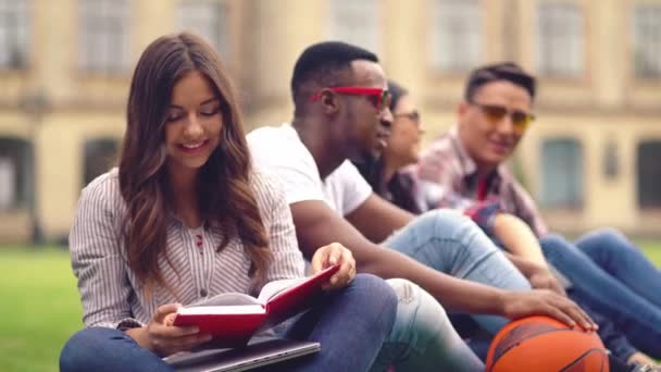 Studenci zabierający książki do biblioteki czytają je na ulicy.. — Wideo stockowe