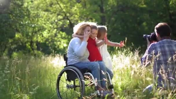 Baba, karısı ve kızıyla tekerlekli sandalyede çekilmiş aile fotoğrafları yapıyor.. — Stok video