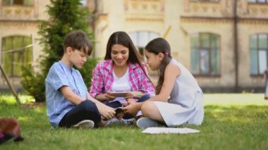 Evde eğitim gören anne, akıllı telefonlar ve eğitim uygulamaları kullanıyor..