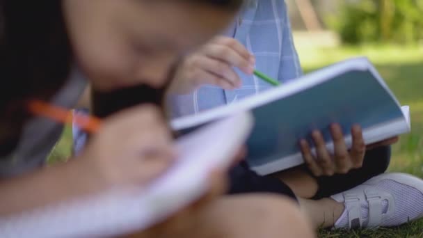 Niños que usan cuadernos para practicar escritura o dibujo a mano . — Vídeo de stock