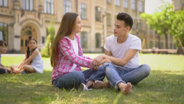 Les adolescents dans l'amour assis à l'extérieur avec frère et sœur plus jeunes — Video