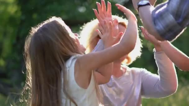 Barn i parken ger femmor till mamma och pappa — Stockvideo