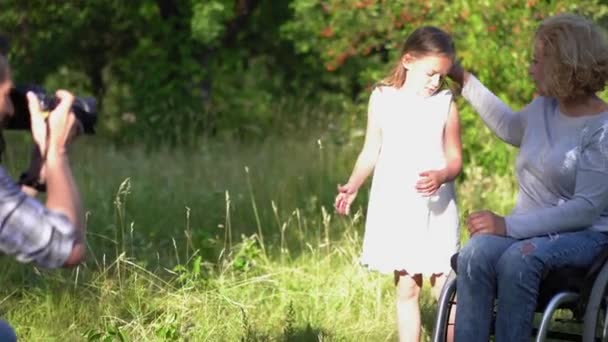 Père faisant la photo de la mère en fauteuil roulant et la fille — Video