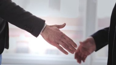 İş adamları pencerenin önünde el sıkışıyor