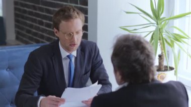 İşadamları restoranda oturan belgeleri imzalıyorlar..