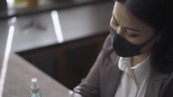 Азиатка, работающая на ноутбуке, сидит в офисе . — стоковое видео