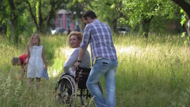 母亲坐在轮椅上的家庭在摄像机前说再见. — 图库视频影像