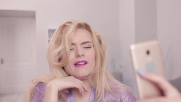 Sexy blond meisje poseren op smartphone camera. — Stockvideo