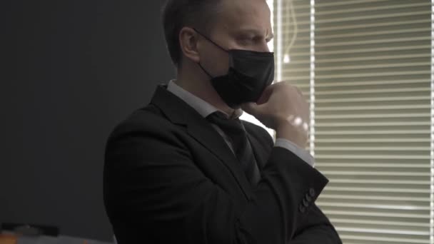Uomo d'affari in giacca e cravatta davanti a una finestra in una zona di quarantena — Video Stock