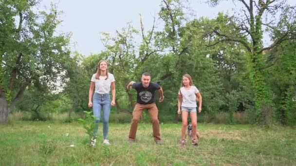 Papá y dos hijas están saltando en el parque — Vídeo de stock