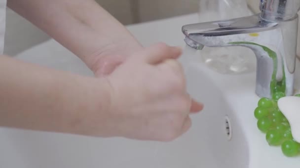 The girl washes her hands thoroughly after arriving home. — Stock Video