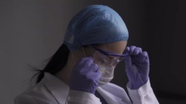 Kişisel güvenliği hiçe sayarak. Doktor tek kullanımlık eldivenlerle yüzüne dokunur..