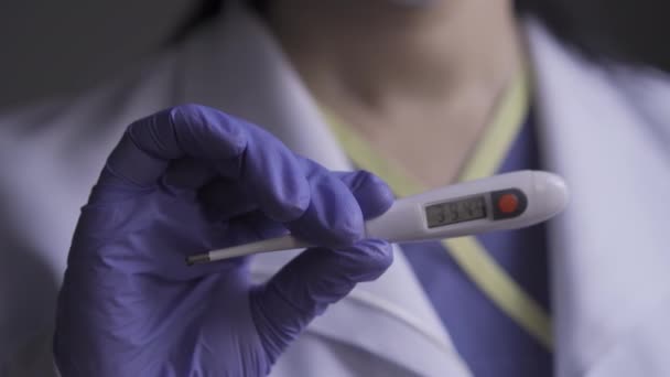 Женщина-врач показывает термометр на камере . — стоковое видео