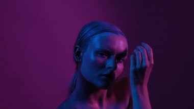 İlginç makyajlı genç kız nazikçe hareket ediyor.