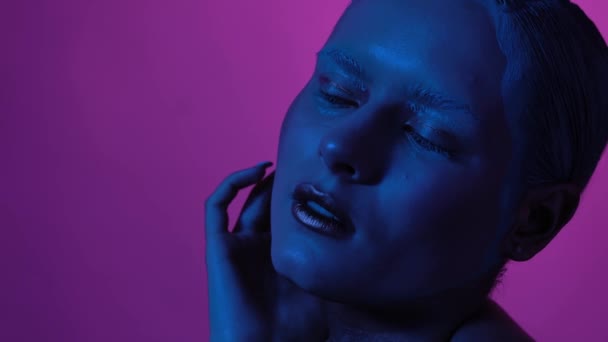 Senhora com maquiagem criativa está brilhando em luzes de néon e — Vídeo de Stock