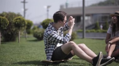 Arkadaş turistler yeni bir şehirde birlikte vakit geçirir ve şehrin arka planında çimlerin üzerinde otururken fotoğraf çekerler. Bir arkadaşım şehrin arka planına karşı bir çiftin fotoğrafını çekiyor. Prores 422
