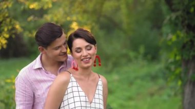 Yakışıklı Adam Yaz Parkı 'nda sevgilisine sarılıyor.