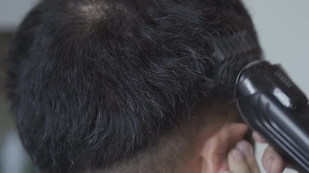 Il parrucchiere taglia un ragazzo a casa. Un giovane uomo si siede su un taglio di capelli a casa durante il periodo di quarantena pandemica. Primo piano. Concetto di parrucchiere. Prore 422 — Video Stock