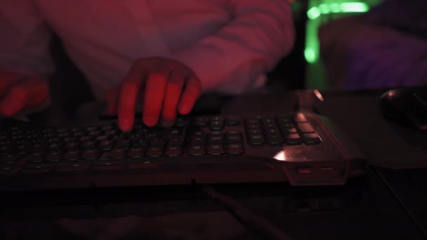 Freelancer digita o scrive una lettera di relazione sul lavoro svolto o scrive un codice IT. Giovane ragazzo con una camicia bianca al computer, a tarda notte in una stanza con luci al neon. Lavora su un sito remoto. Prore 422 — Video Stock