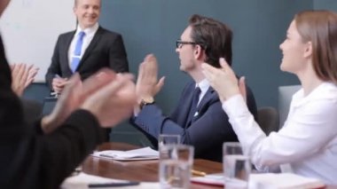 Yeni bir projenin başarılı bir sunumundan sonra meslektaşlarını alkışlayan bir grup serbest çalışanı yakından takip edin.