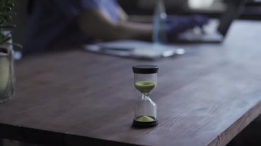 Kum saatinde zaman akıyor. Hemşire ofisteki bir bilgisayar ya da dizüstü bilgisayarın başına oturur ve Coronavirus hastaları için yapılan testlere ilişkin bilgileri girer ya da günceller. Sağlık hizmeti konsepti. Prores 422