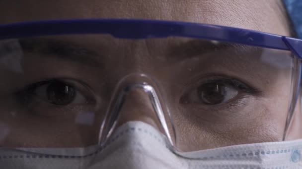 Крупним планом втомлені очі лікаря, який дивиться на камеру в масці забруднення та окулярах. Концепція охорони здоров'я. Пропозиції 422 — стокове відео
