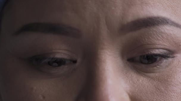 Eine Nahaufnahme des Auges einer Frau, die in die Kamera blickt und enttäuscht die Augen senkt, nachdem sie erfährt, dass sie einen Coronavirus-positiven Test hat. Gesundheitskonzept. Prores 422 — Stockvideo