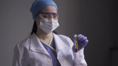 Laboratuvar teknisyeni ya da doktor elinde üzerinde CARVID 19 etiketi olan hastanın kanının bulunduğu bir test tüpü tutuyor. Sağlık hizmeti konsepti. Prores 422
