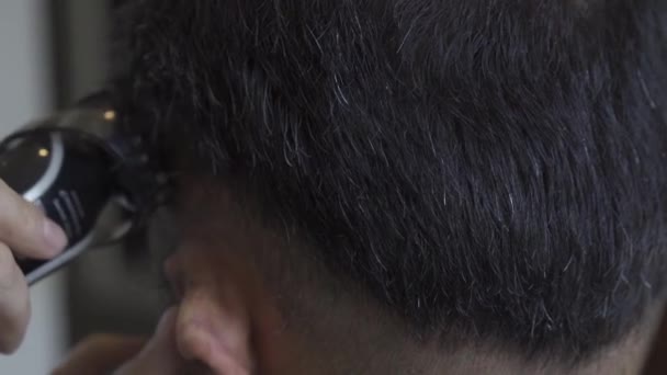 De kapper knipt het haar van een jongeman. Close-up op het hoofd van een jonge man, kapper uitlijnt knippen haar over oor. Prores 422 — Stockvideo