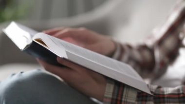 Genç bir adam evdeki kanepede büyükannesi ya da babasıyla otururken İncil okur. Genç bir Hıristiyan, İncil okuyarak inançla kurulur. Kitabı ellerinle kapat. Prores 422