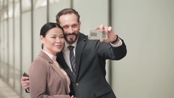 Podnikatelé si berou selfie, když stojí vedle obchodního centra. Muž a žena v obchodních šatech na pozadí obchodního centra. Obchodní koncept. Prores 422 — Stock video