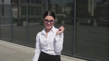 Mutlu iş kadını elinde Bitcoin ile modern iş merkezinin yanındaki caddede duruyor. İş konsepti. Prores 422
