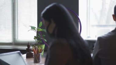Koruyucu maskeli genç bir adam, kirlilik maskeli bir kadının önünde iş görüşmesi yapıyor. Serbest çalışan firma gençleri takımlarına katılıp açık bir gün geçirmeleri için davet etti. Seçici odak.
