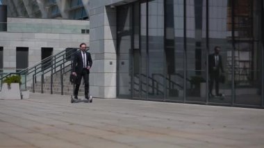 Modern bir işadamı, modern bir iş merkezinin önünden geçen bir jiroskop üzerinde çalışacak. İş hayatında evrim. Yaklaş. İş konsepti. Prores 422