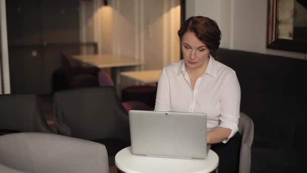 Επιχειρηματίας εργάζεται σε ένα φορητό υπολογιστή κάθεται στην πολυθρόνα περιμένοντας έναν πελάτη. Μια επιχειρηματίας αναπτύσσει ένα έγγραφο ή ανταποκρίνεται σε μια επαγγελματική επιστολή... γυναίκα στην επιχειρηματική ιδέα. Πρότυπα 422 — Αρχείο Βίντεο