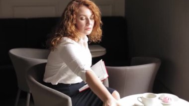 Bir iş kadını elinde notları olan bir günlük tutar, masadan bir akıllı telefon ya da telefon alır ve rahat bir kafede otururken takvim girdilerini karşılaştırır. Prores 422