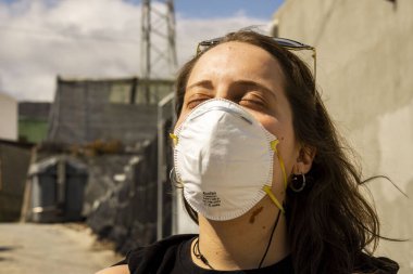 Güneş banyosu yapan bir kadın maske takıyor.
