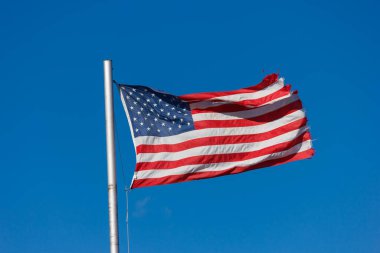 Mavi gökyüzüne karşı Amerikan bayrağı.