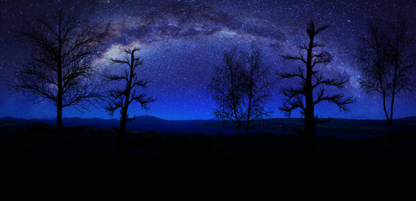 Milky way night panorama with silhuettes of mountains and trees.